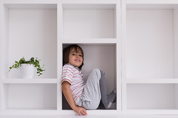 Image showing young boy posing on a shelf