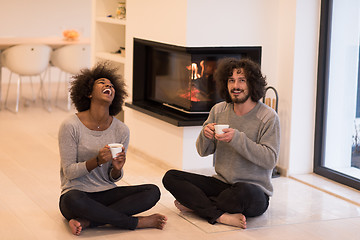 Image showing multiethnic couple  in front of fireplace