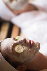 Image showing woman is getting facial clay mask at spa