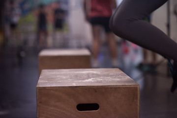 Image showing black woman is performing box jumps at gym