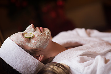 Image showing woman is getting facial clay mask at spa