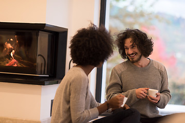 Image showing multiethnic couple  in front of fireplace