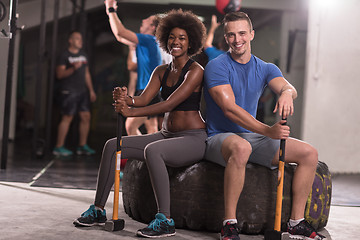 Image showing multiethnic couple after workout with hammer