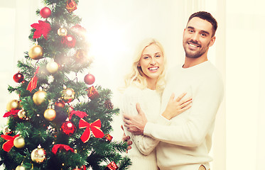 Image showing happy couple hugging near christmas tree at home