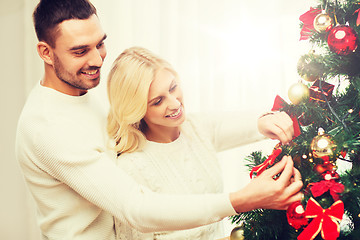 Image showing happy couple decorating christmas tree at home