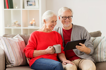 Image showing happy senior couple with tablet pc at christmas