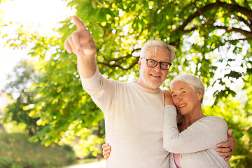 Image showing happy senior couple hugging at summer park