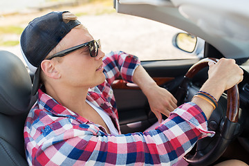 Image showing happy young man driving convertible car