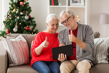 Image showing happy senior couple with tablet pc at christmas