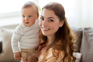 Image showing happy young mother with little baby at home