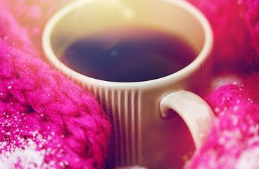 Image showing close up of tea or coffee and winter scarf in snow