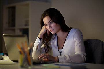 Image showing businesswoman with laptop at night office