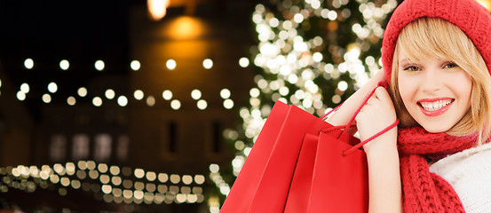 Image showing happy woman with shopping bags over christmas tree