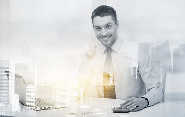 Image showing smiling businessman with laptop and documents