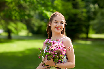 Image showing happy young woman with flowers in summer park