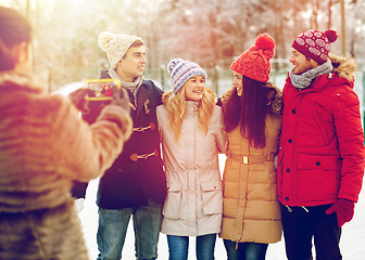 Image showing happy friends taking picture with smartphone