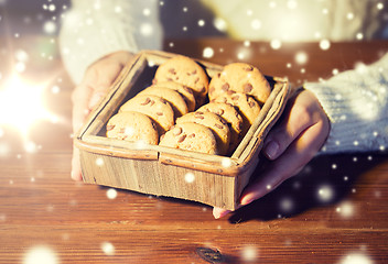 Image showing close up of woman with oat cookies at home