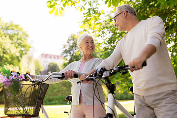 Image showing happy senior couple with bicycles at summer park
