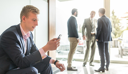 Image showing Businessman using smart phone while sitting in waiting room.