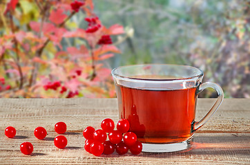 Image showing Tea with viburnum berries on wooden table