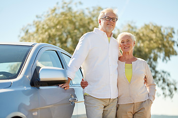 Image showing happy senior couple hugging at car in summer