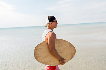 Image showing happy young man with skimboard on summer beach