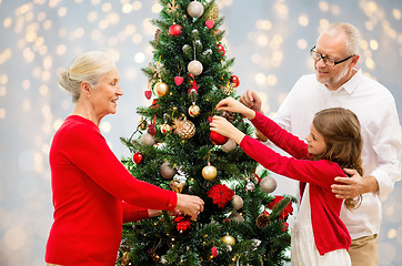 Image showing grandparents and granddaughter at christmas tree