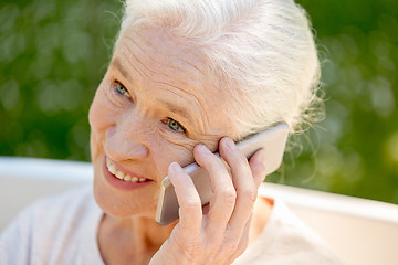 Image showing happy senior woman calling on smartphone in summer