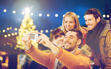 Image showing happy friends with camera taking christmas selfie