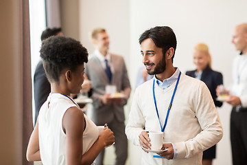 Image showing business people with conference badges and coffee