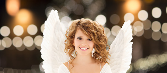 Image showing happy woman with angel wings over christmas lights