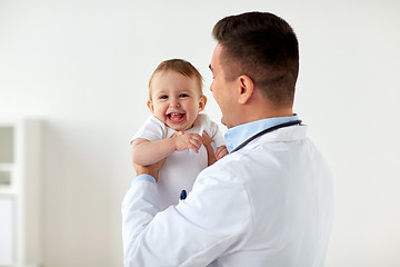 Image showing happy doctor or pediatrician with baby at clinic