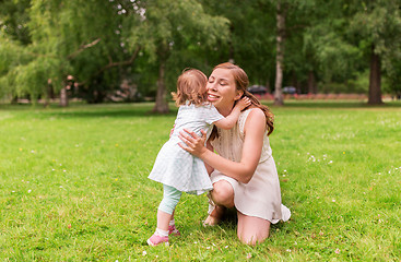 Image showing happy mother hugging baby girl at summer park