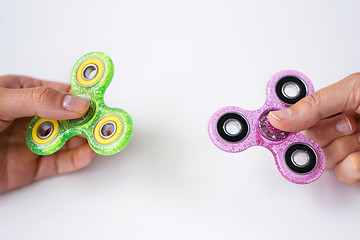 Image showing close up of two hands playing with fidget spinners