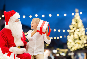 Image showing santa claus and happy boy with christmas gift