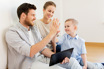 Image showing family with tablet pc at new home making high five