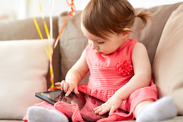 Image showing baby girl with tablet pc sitting on sofa at home