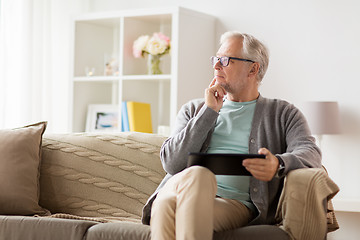 Image showing senior man with tablet pc sitting on sofa at home