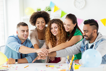 Image showing happy team at office party holding hands together