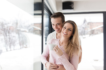 Image showing young couple enjoying morning coffee by the window