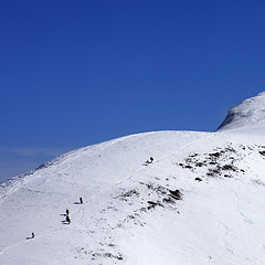 Image showing Snowboarders and skiers downhill on off piste slope at sun day