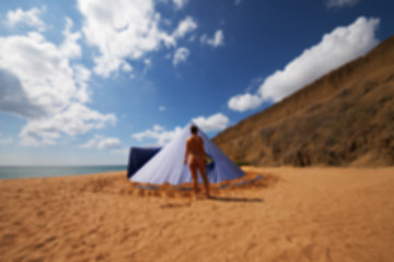 Image showing Blurred view of conical tent and sunbathing girl on summer beach