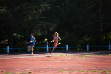 Image showing Blurred view of woman athletic running competition at stadium