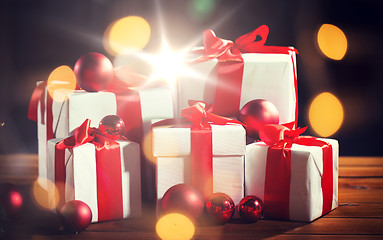 Image showing gift boxes and red christmas balls on wooden floor