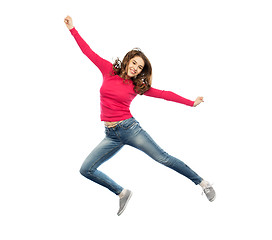 Image showing smiling young woman jumping in air