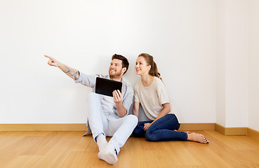 Image showing happy couple with tablet pc computer at new home