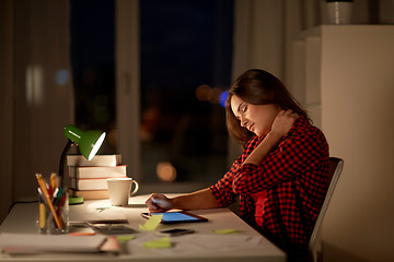 Image showing tired student or woman touching neck at night home