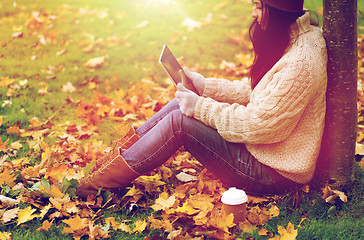 Image showing woman with tablet pc and coffee in autumn park