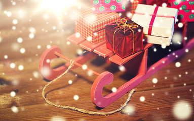 Image showing close up of christmas gift boxes on wooden sleigh