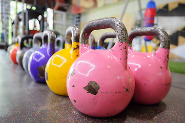 Image showing colorful kettlebells in a row in a gym